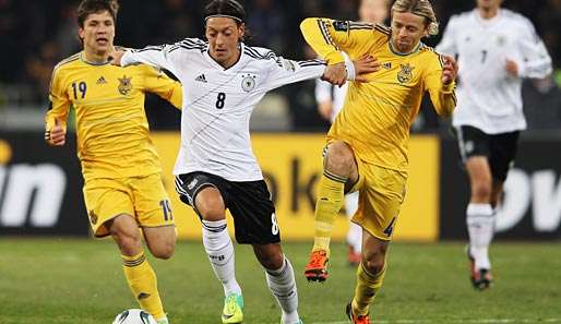 Anatoli Timoschtschuk (r.) für die Ukraine gegen Mesut Özil (M.)