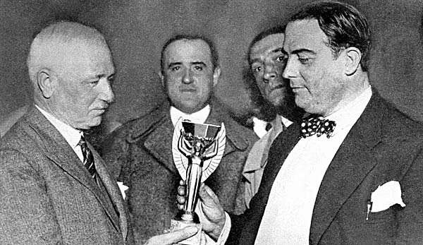 FIFA-Präsident Jules Rimet (l.) übergibt dem Präsidenten des uruguayischen Fußballverbandes, Dr. Raus Jude, den WM-Pokal.