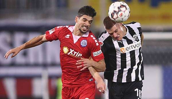  Enis Hajri von Duisburg im Kopfballduell mit dem Sandhauser Kevin Behrens.