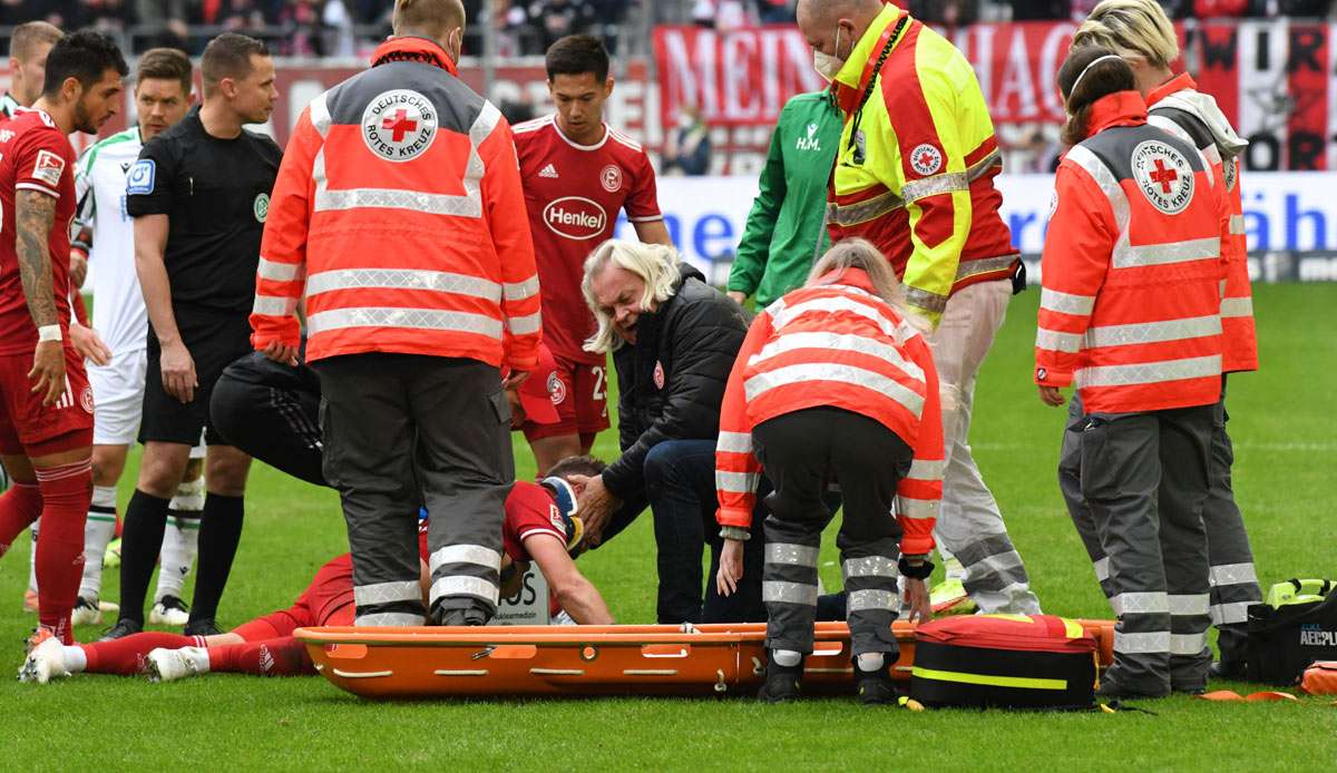 Der Düsseldorfer Andre Hoffmann wird nach einem Zusammenprall auf dem Platz behandelt.