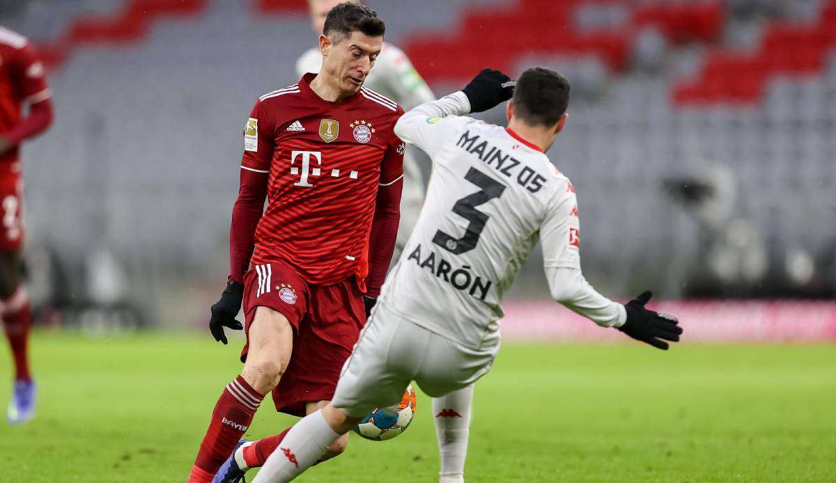 Robert Lewandowski versucht den Ball am Mainzer Aaron Martin vorbeizulegen.