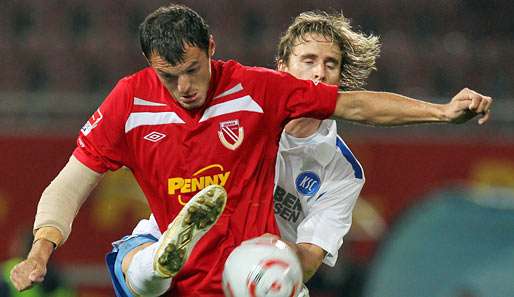 Cottbus' Stürmer Emil Jula (l.) wird von einem KSC-Spieler bearbeitet