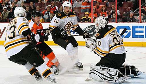 Gemeinsam stoppen Bruins-Goalie Tim Thomas (r.) und seine Vordermänner Darroll Powe (2. v. l.)
